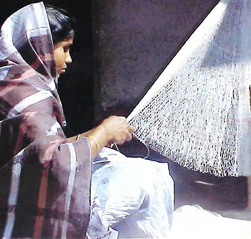 Woman weaving a fishing net Woman weaving a fishing net
